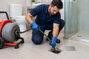 Profissional trabalhando no desentupimento de um ralo.